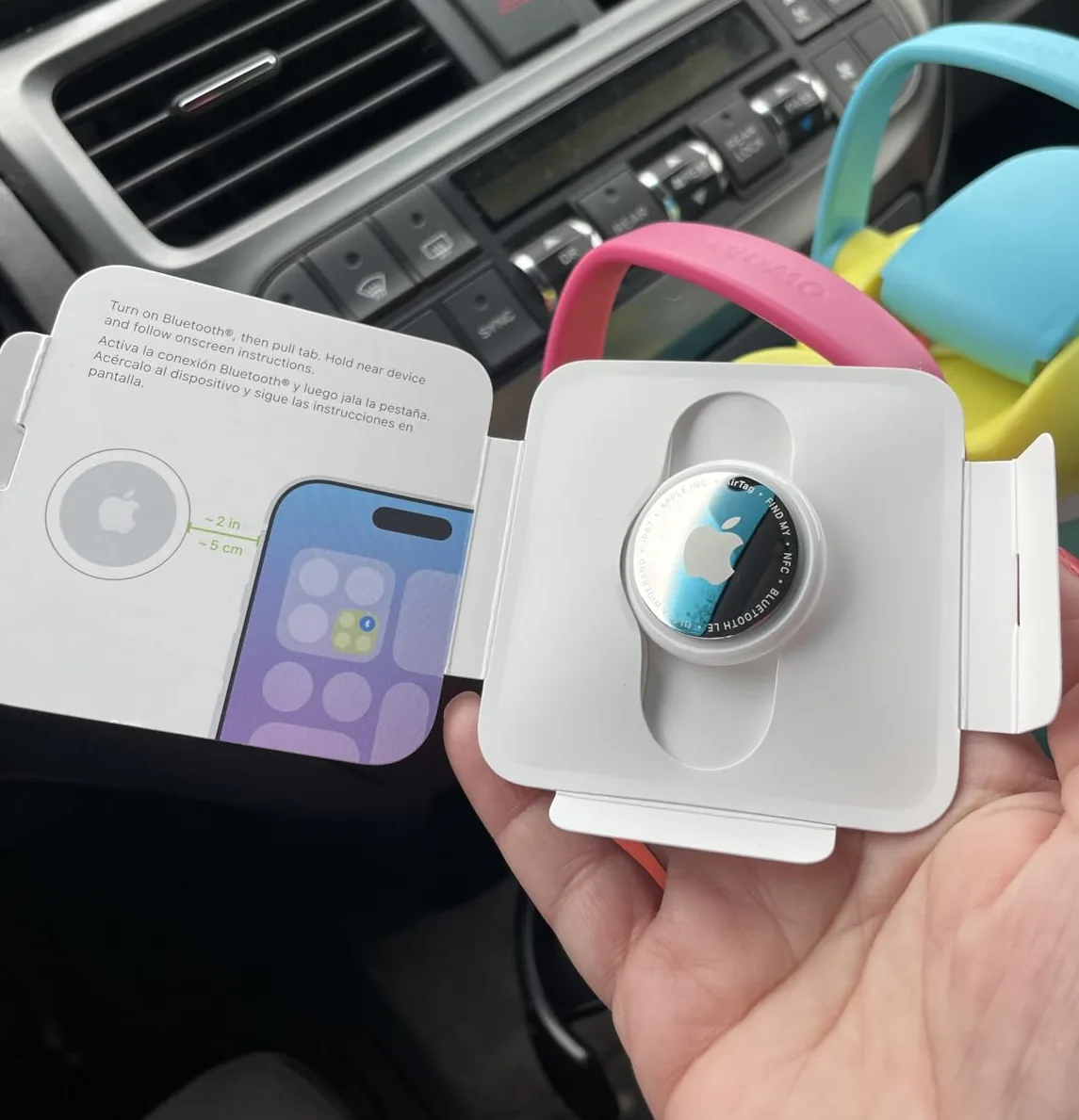 Apple AirTag held up in its open packaging