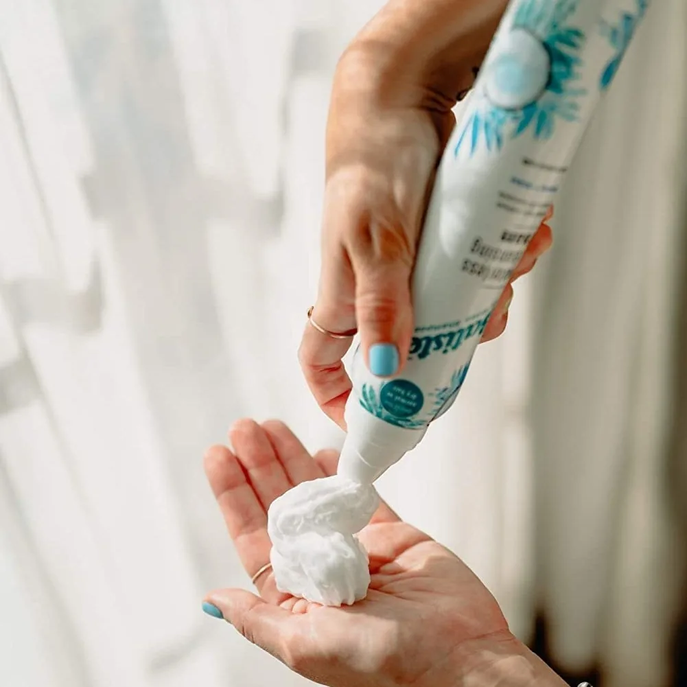 Batiste waterless cleansing foam dispensed into an open palm