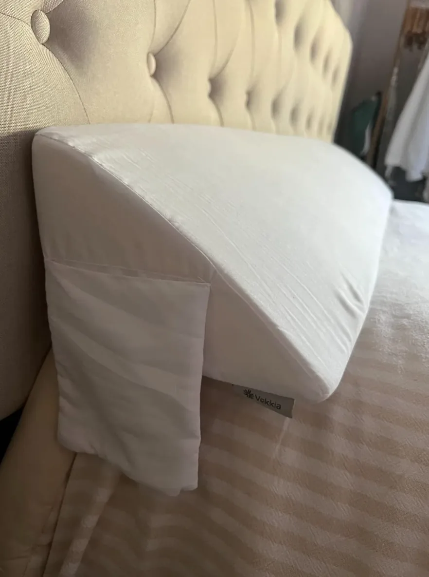 Foam bed wedge filling the gap between a mattress and a tufted headboard