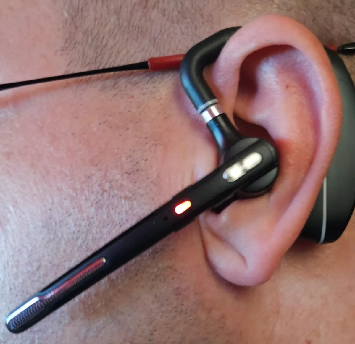 Bluetooth earpiece with a flexible over-ear hook and slim boom mic worn on one ear