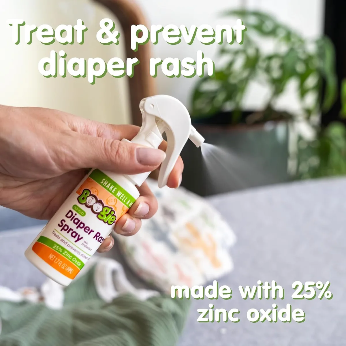 Hand holding a bottle of Boogie Bottoms no-rub diaper rash spray