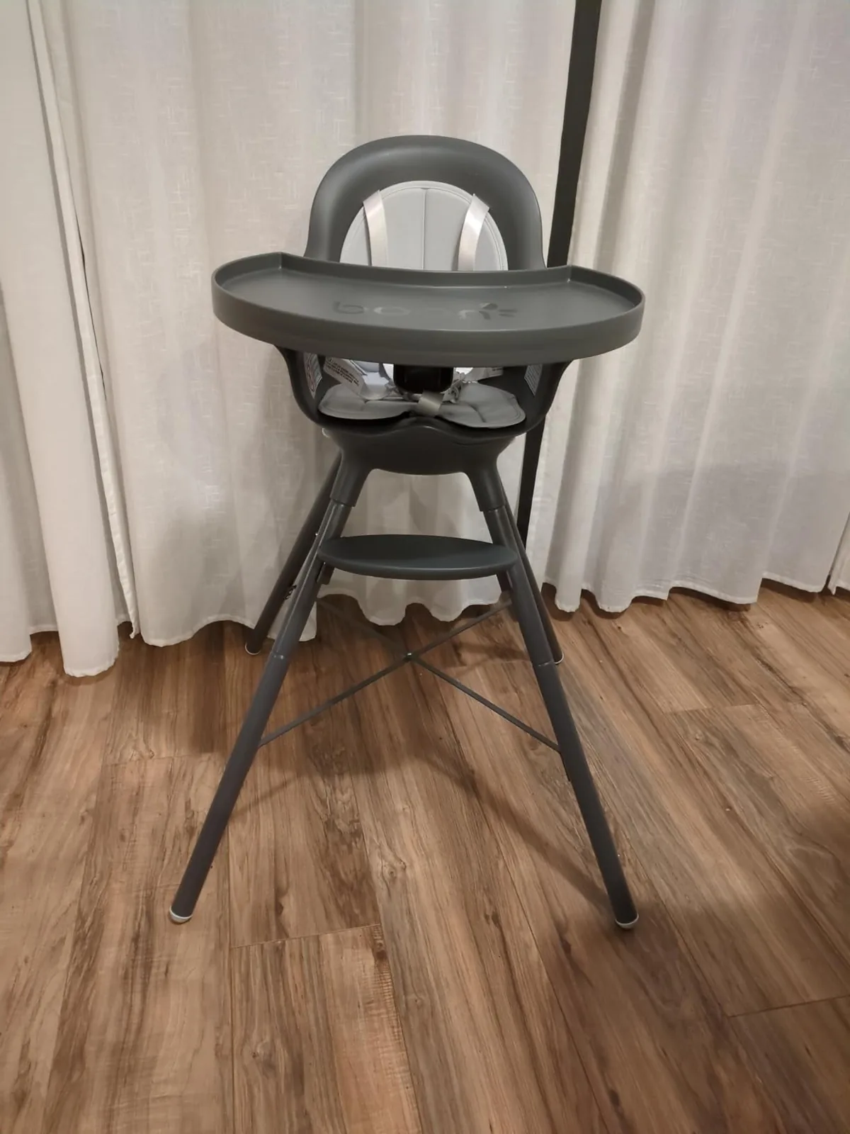 Gray Boon Grub counter-height high chair with rounded tray on a wood floor