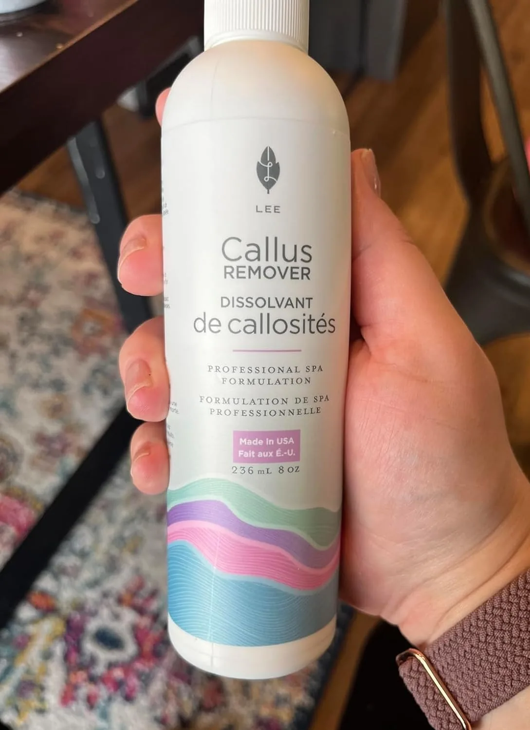 Hand holding a bottle of Lee Beauty callus remover gel