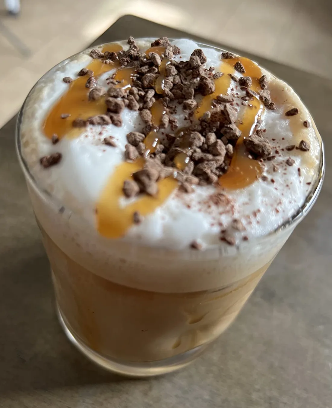 Iced coffee topped with cream and a caramel sauce drizzle