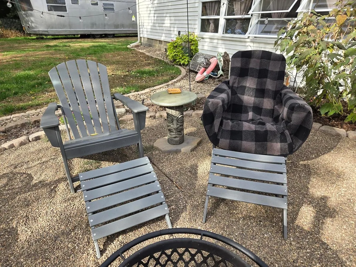 Outdoor chairs draped in checkered fleece chair blankets beside a fire