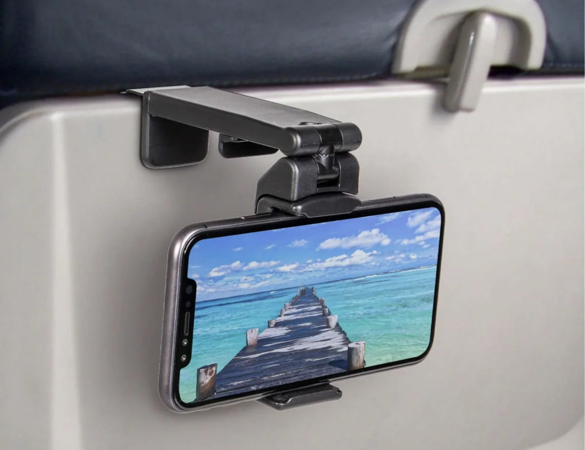 Phone held by a clip-on mount attached to an airplane tray table
