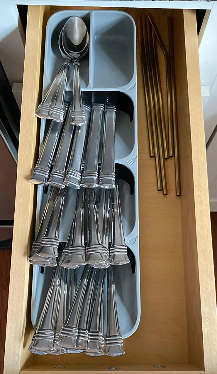 Slim tiered cutlery organizer in a narrow kitchen drawer