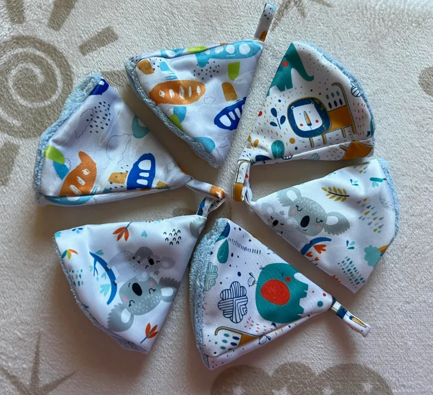 Six patterned absorbent pee teepees for baby boys arranged in a circle