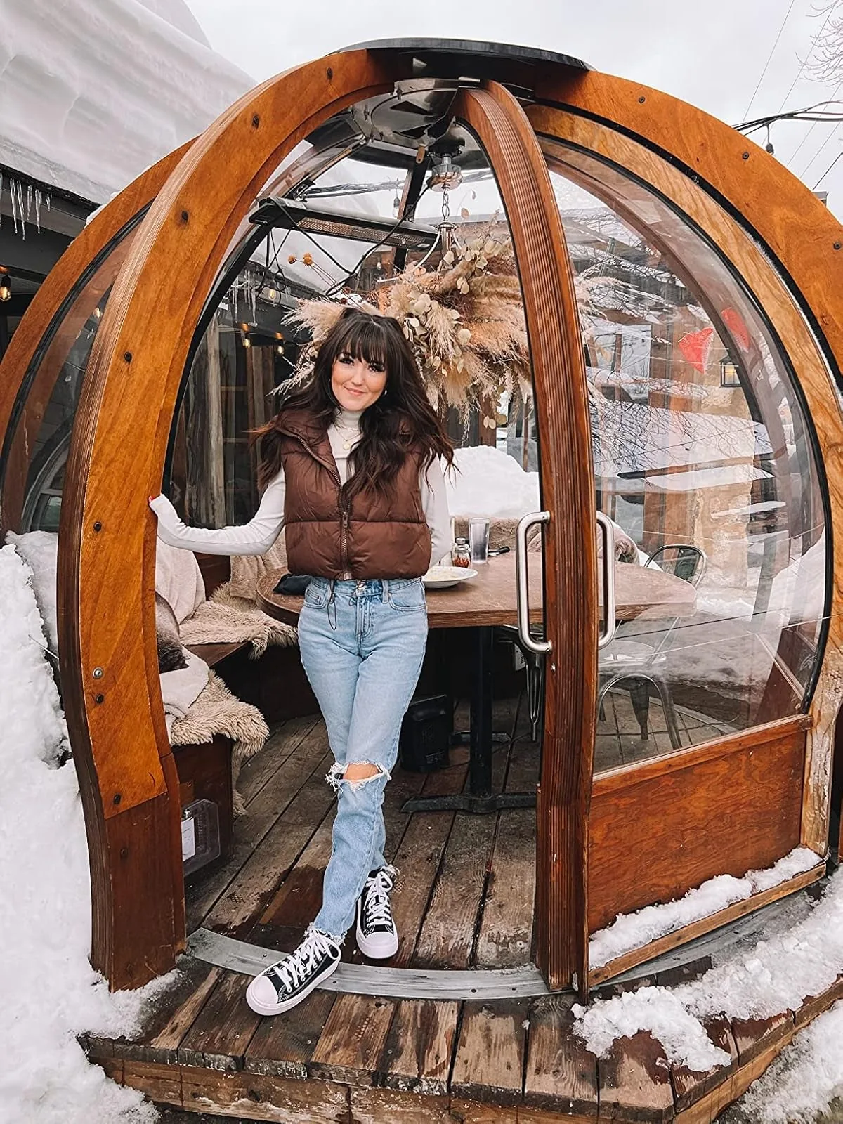 Cropped brown puffer vest worn over a long-sleeve top