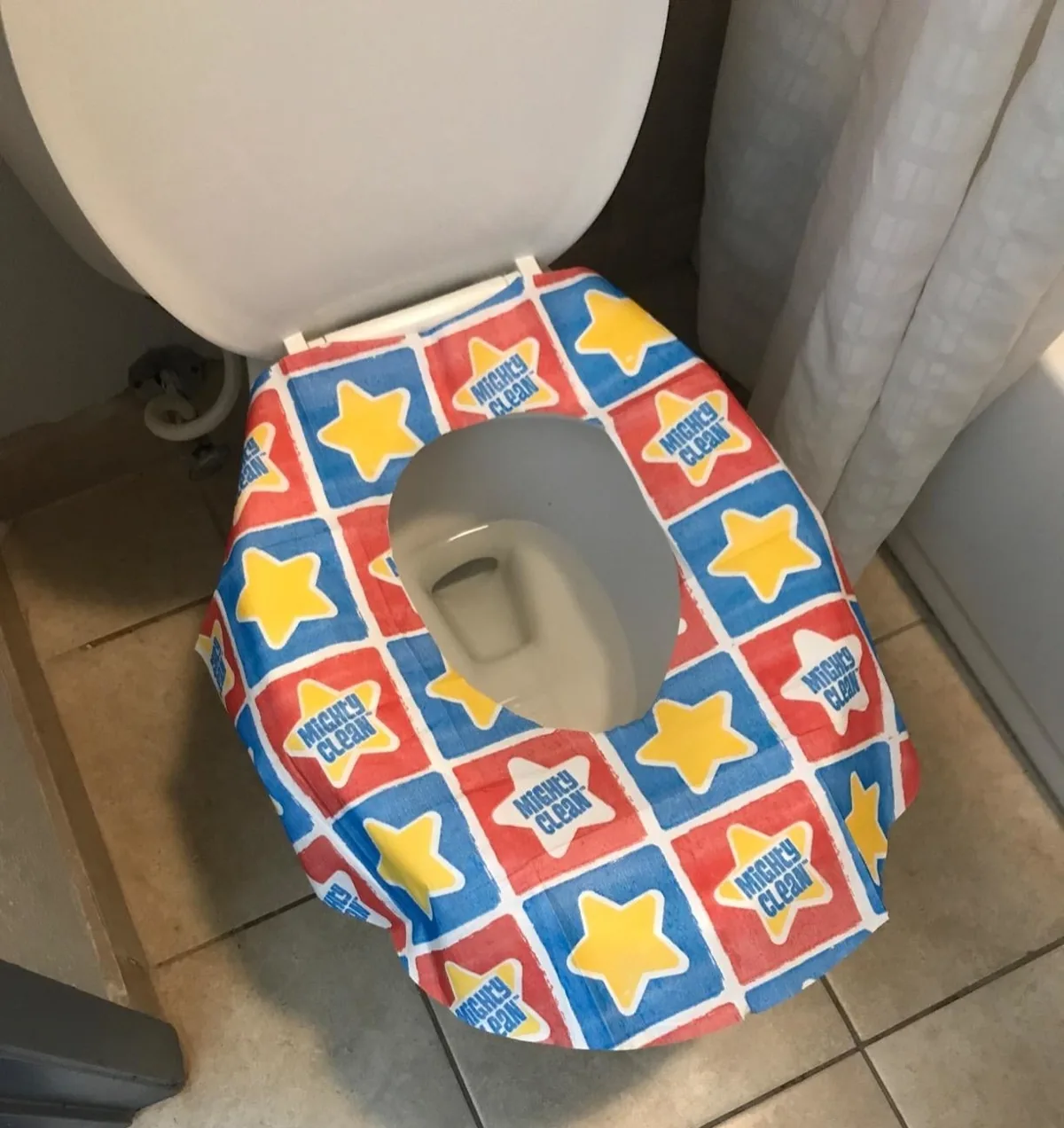 Disposable paper seat cover laid over a public toilet seat