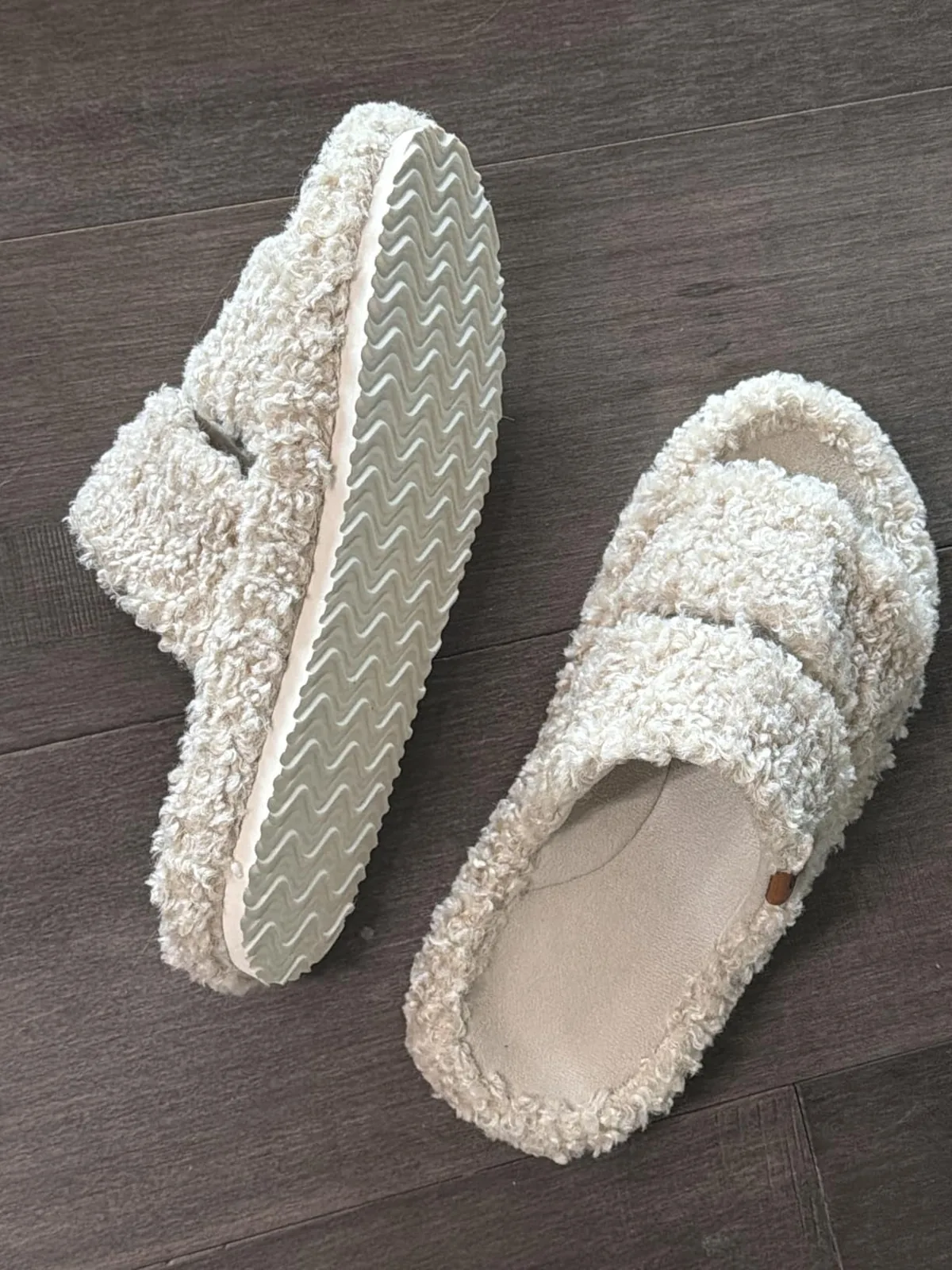Fuzzy EverFoams open-toe slippers with non-slip soles on a wooden floor