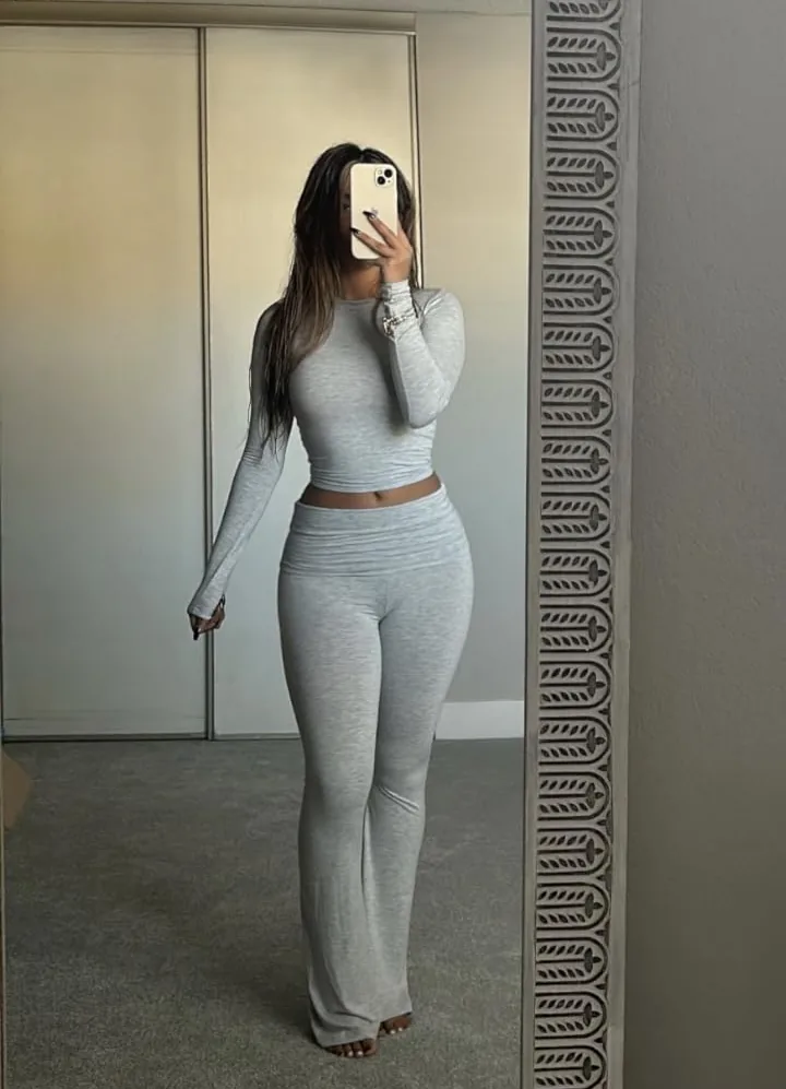 Black fitted long-sleeve top with matching foldover flare pants