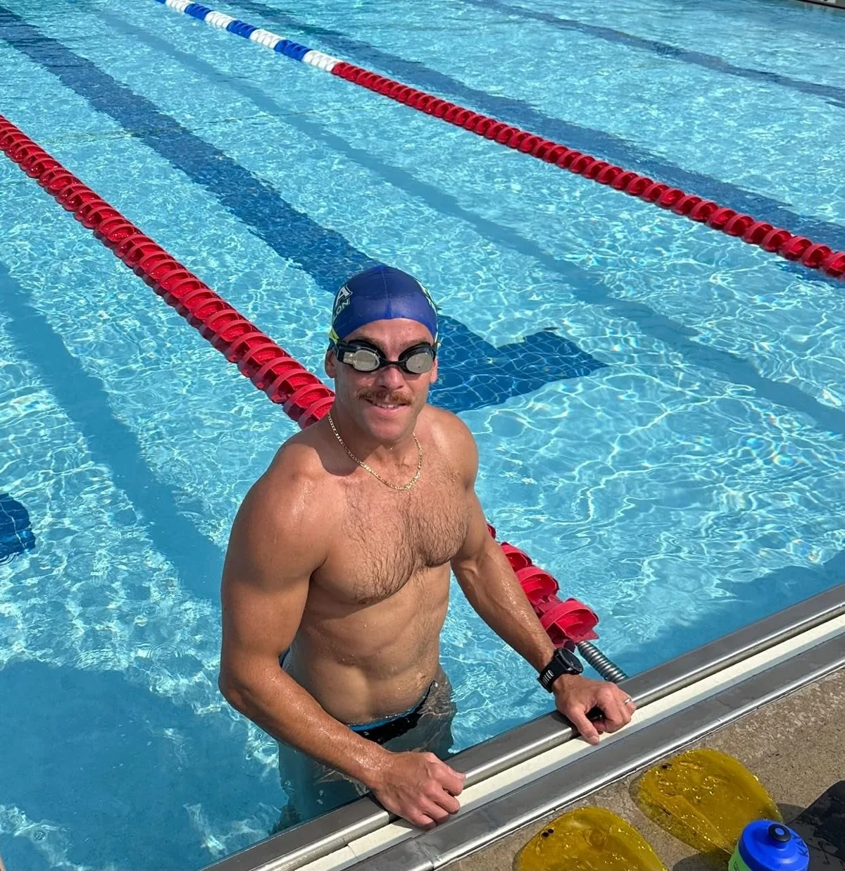 Swimmer at the edge of a pool wearing FORM smart swim goggles