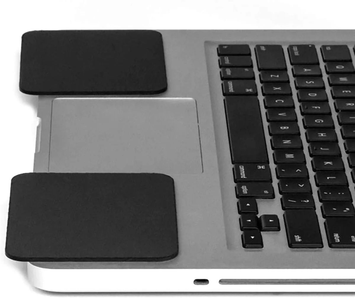 Black Grifiti wrist rest pads on both sides of a laptop trackpad
