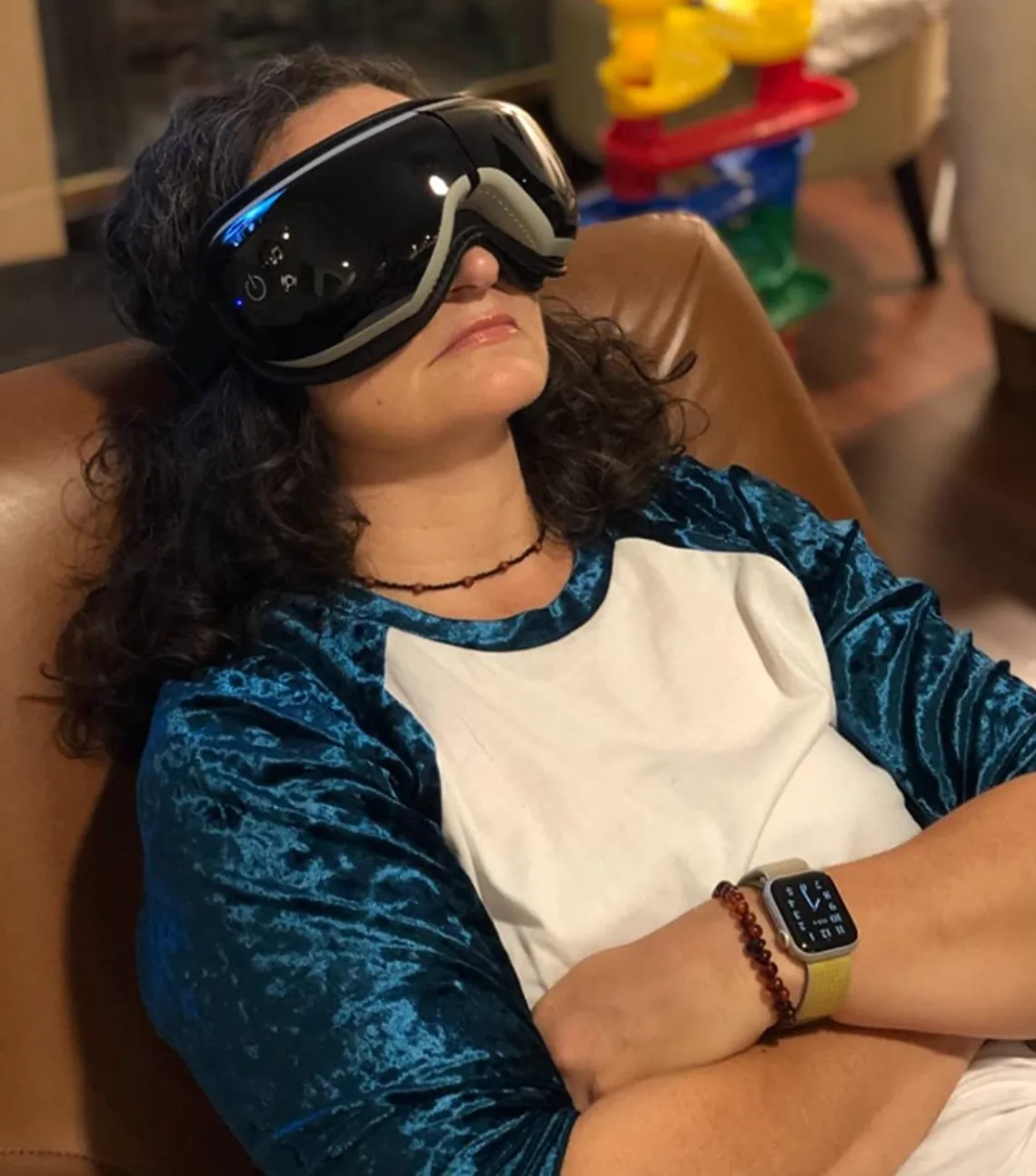 Person wearing a black goggle-style heated eye massager