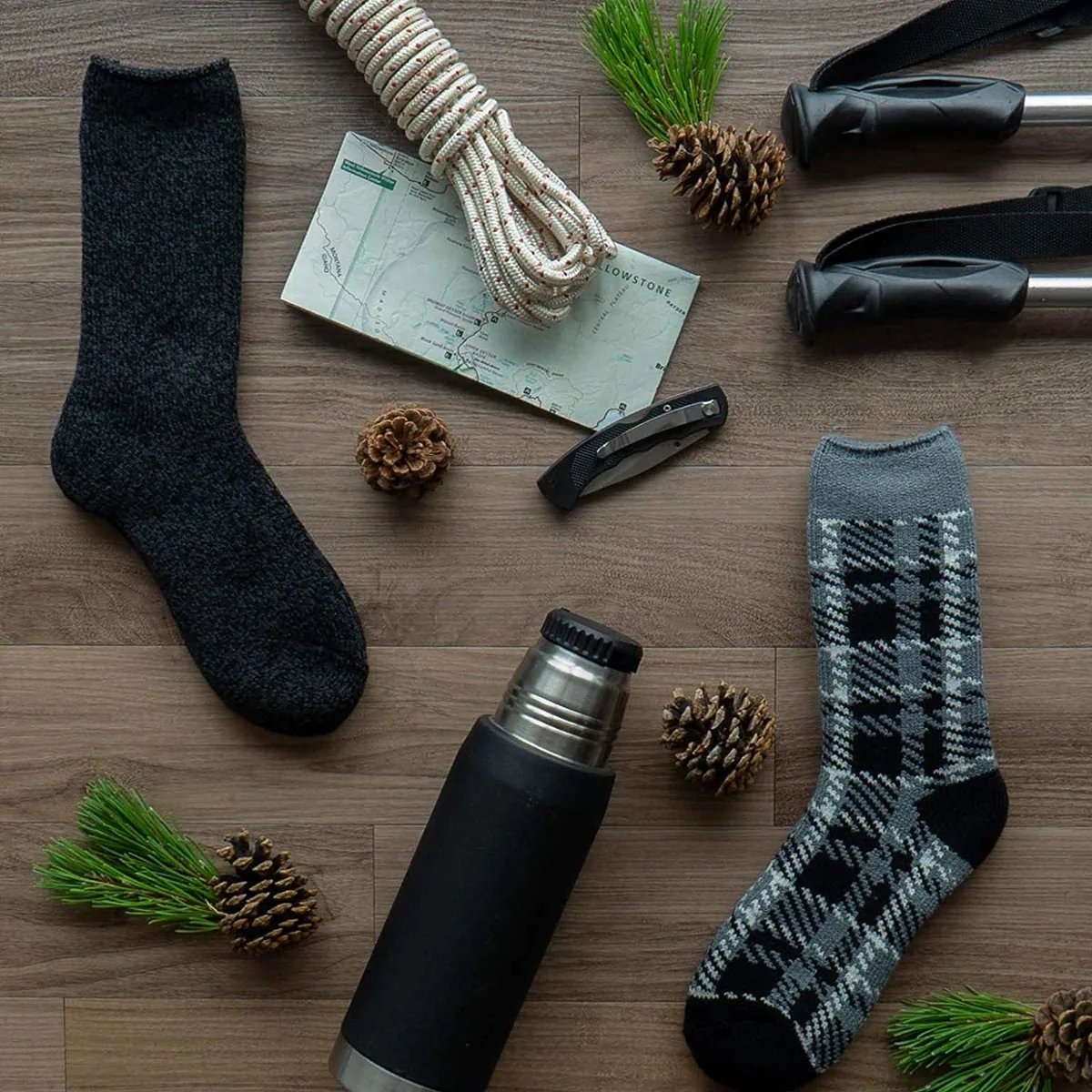 Charcoal and gray plaid Hot Feet thermal socks laid out on a wooden floor