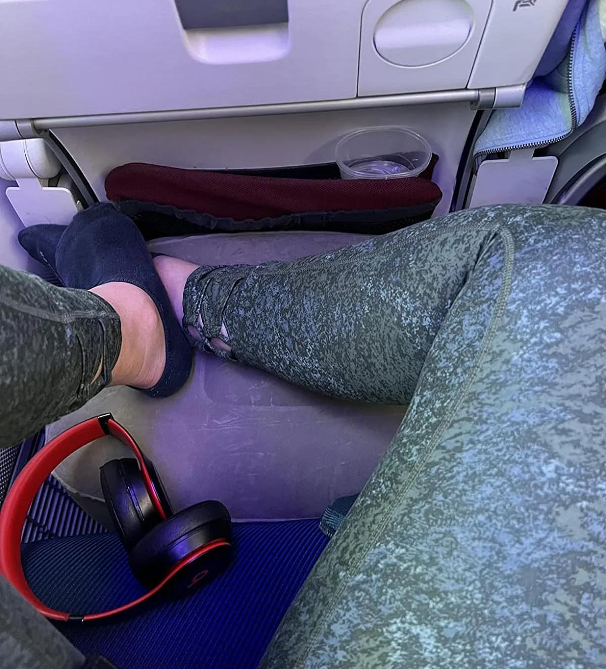 Inflatable footrest pillow set up in front of an airplane seat