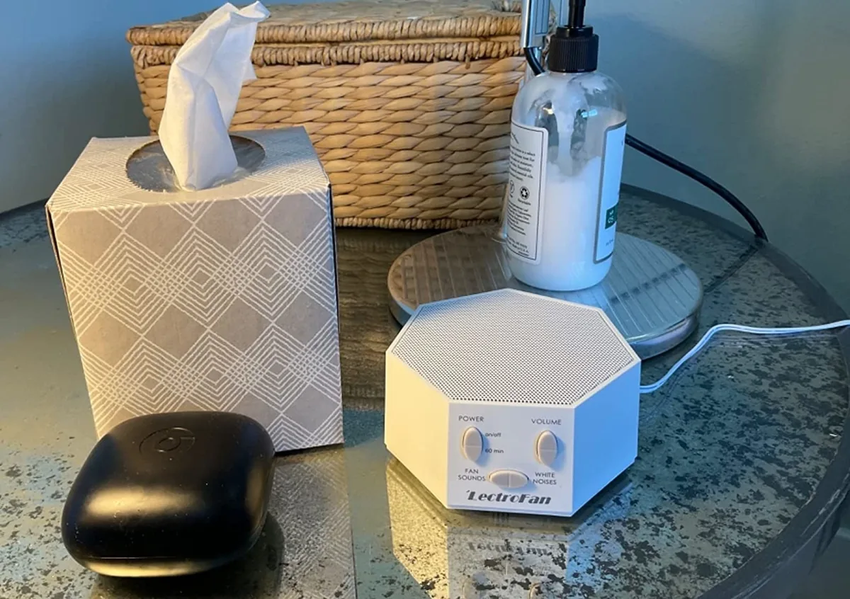 White LectroFan white noise machine on a bedside table