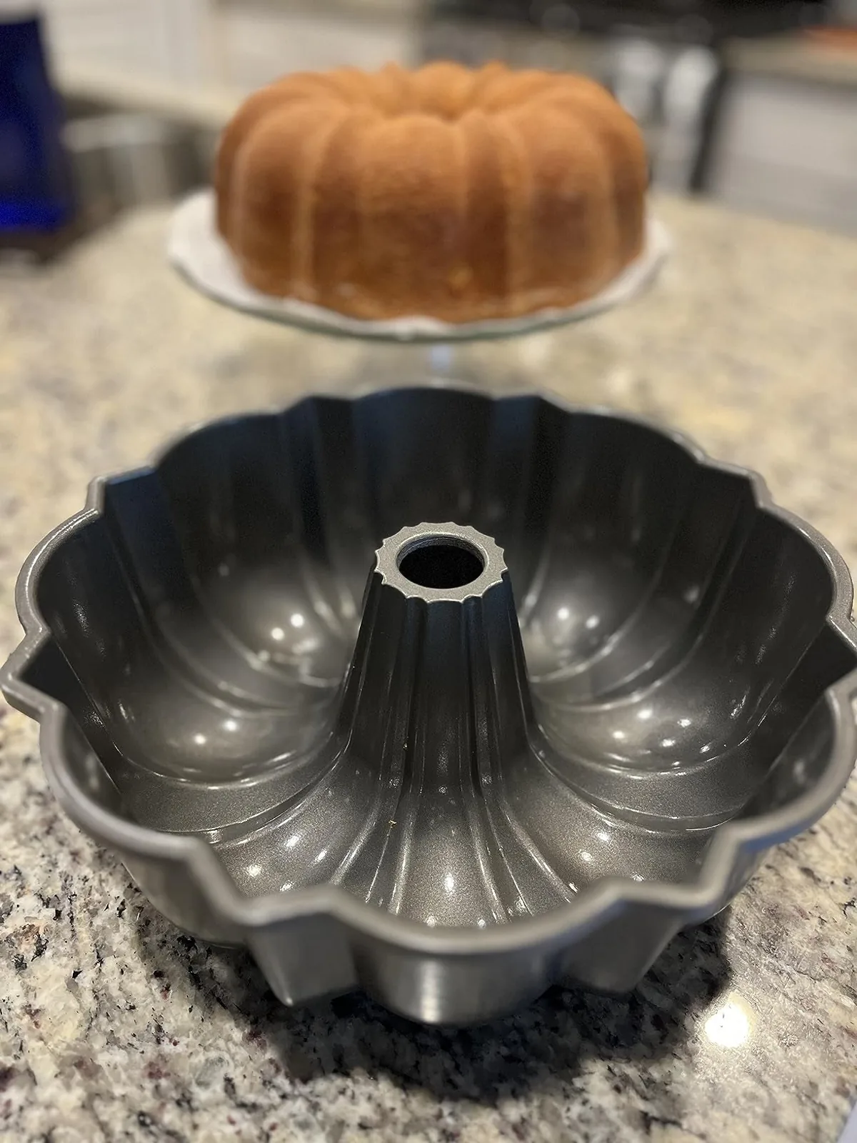 Bronze Nordic Ware Bundt pan in focus with a baked Bundt cake behind it