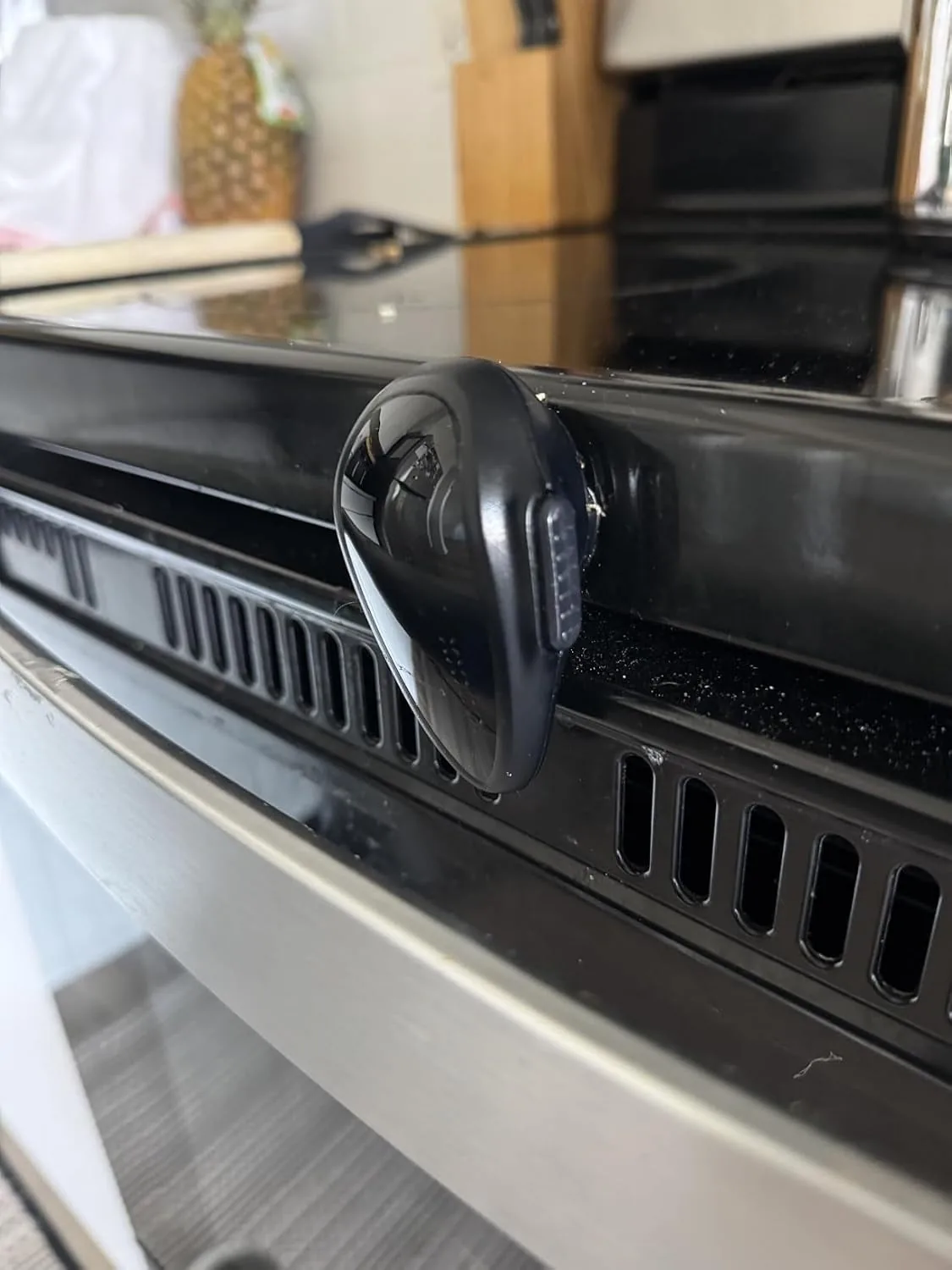 Black childproof lock attached to the front of an oven door