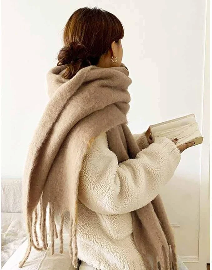 Camel oversized fringed scarf wrapped over a cream coat