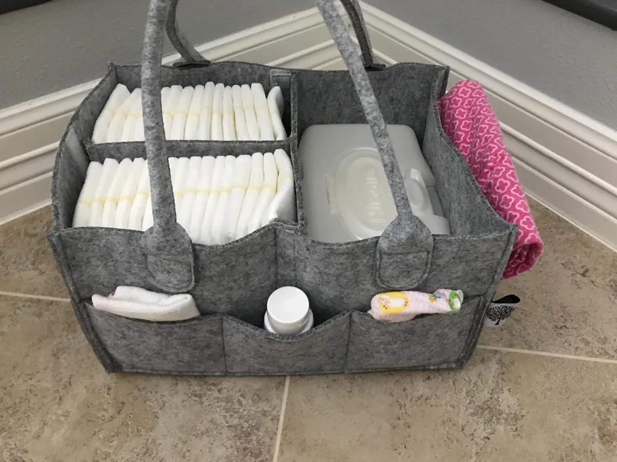 Grey felt diaper caddy filled with diapers, wipes and baby supplies