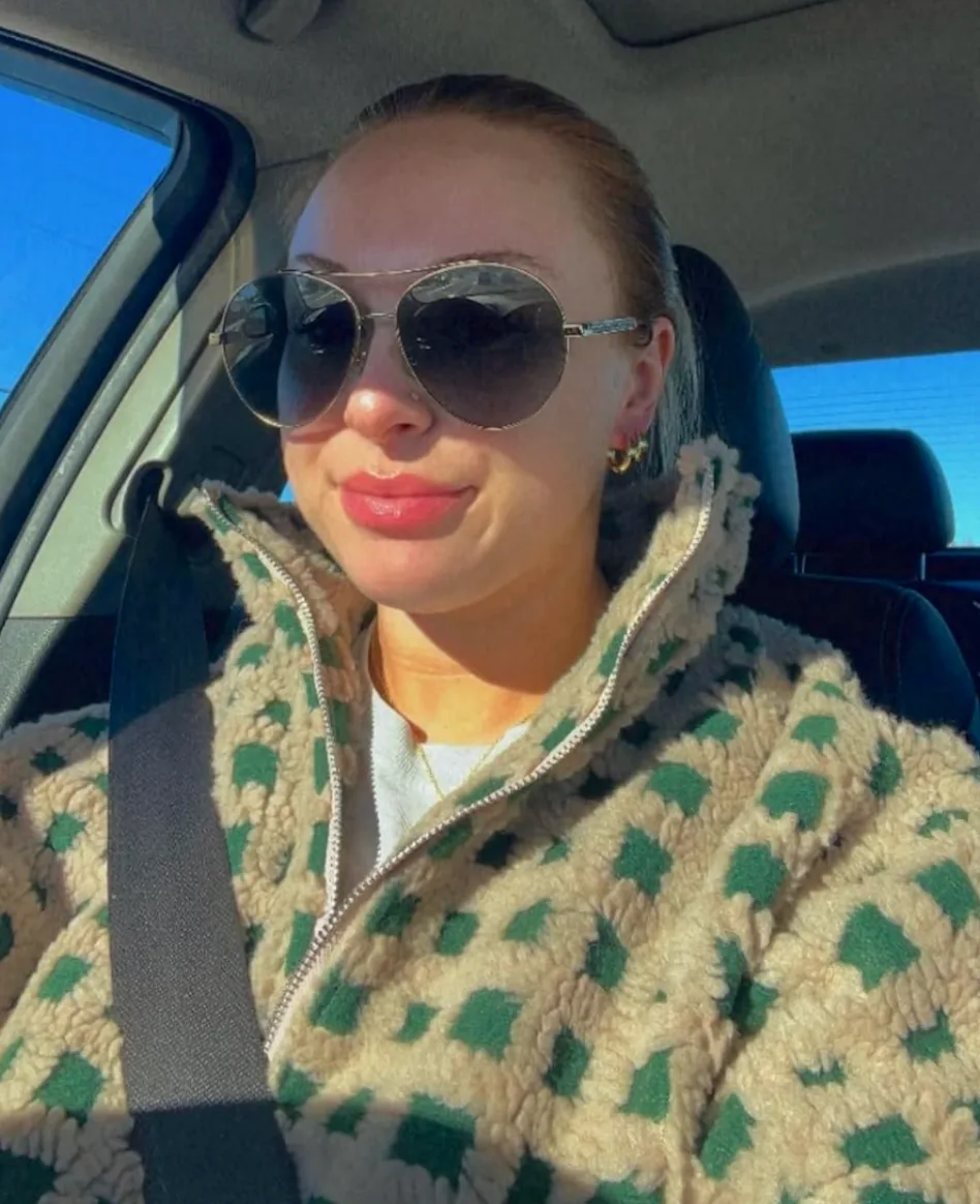Patterned fleece jacket worn with sunglasses in a car