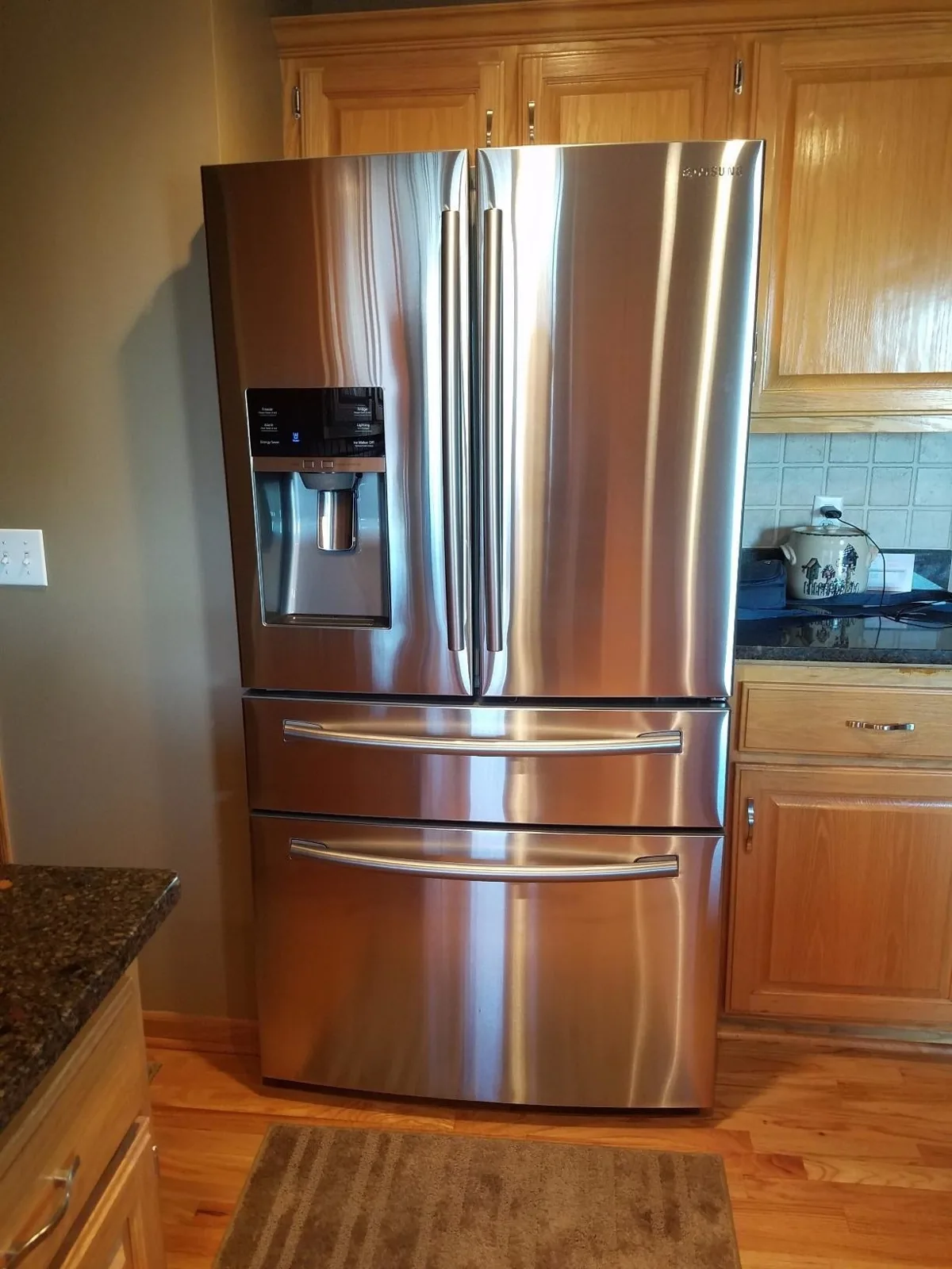 Gleaming stainless steel French door refrigerator in a wood kitchen