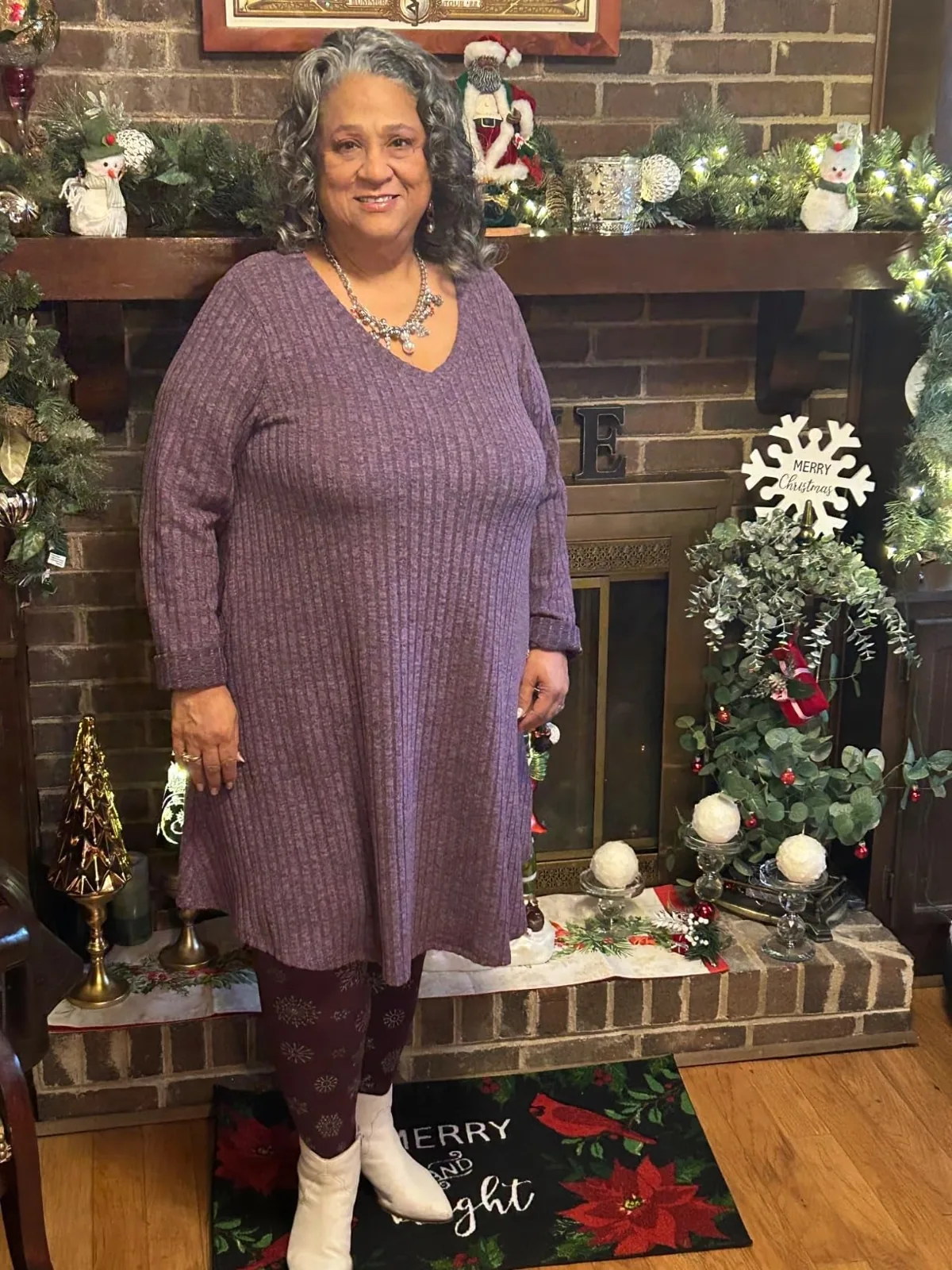 Loose V-neck sweater dress with long sleeves worn over patterned leggings