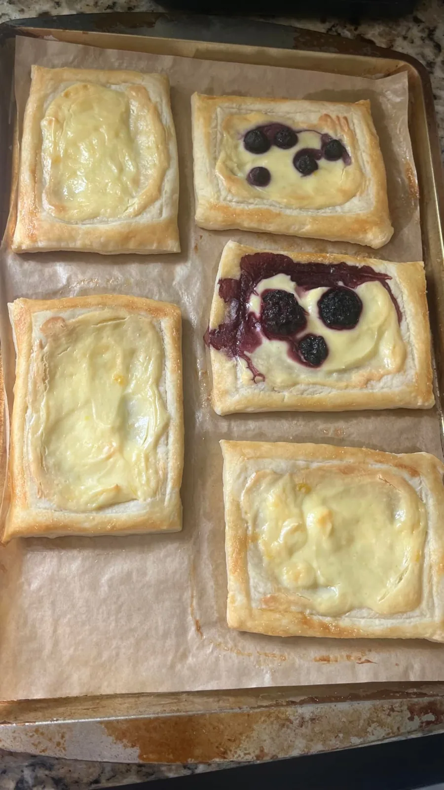 Golden pastries with creamy filling baked on a sheet of parchment paper