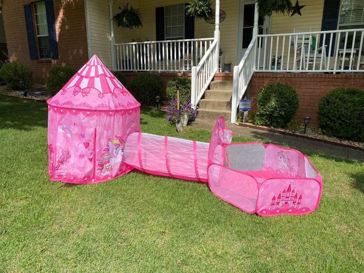 Pink castle play tent connected to a crawl tunnel and ball pit