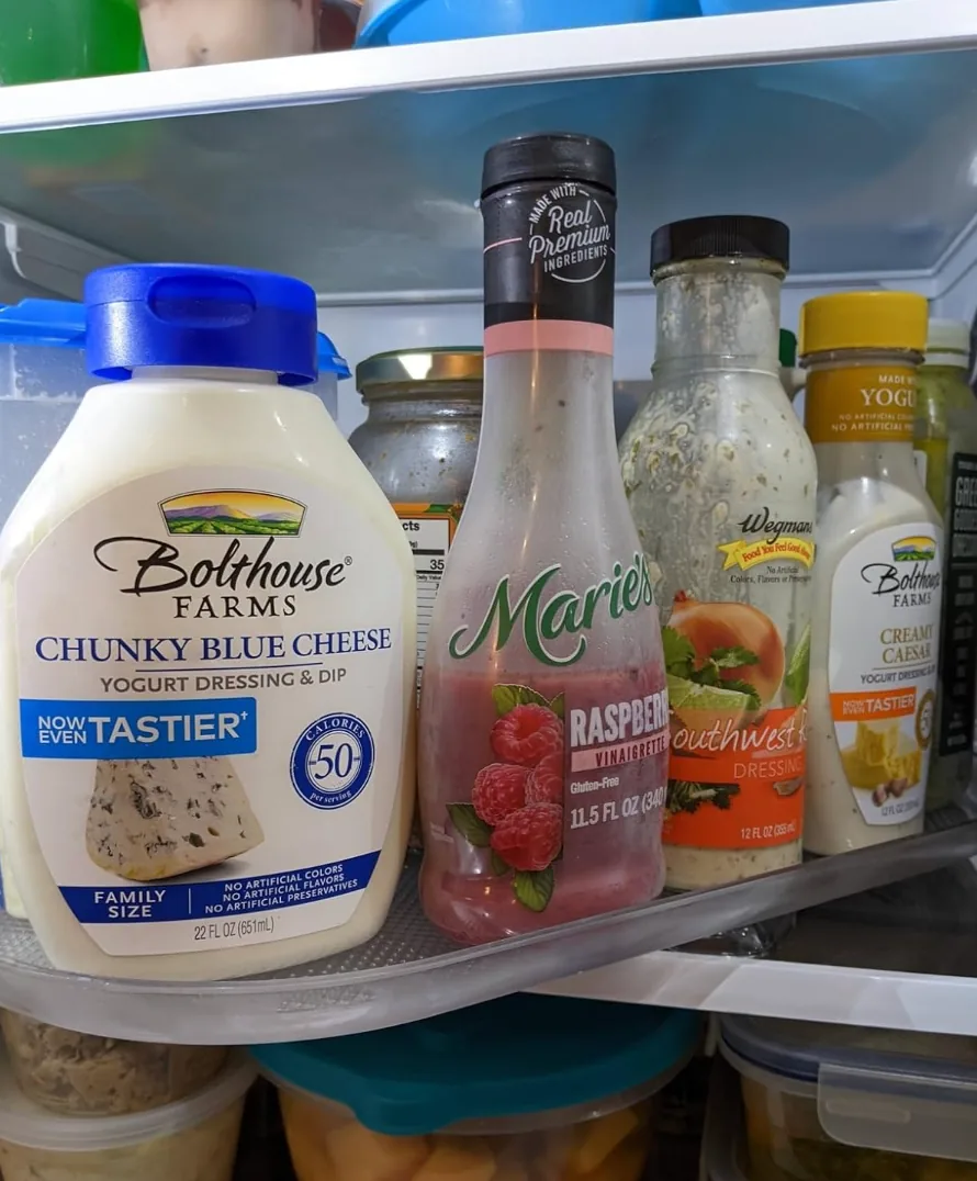 Condiment jars on a clear rectangular turntable inside a refrigerator