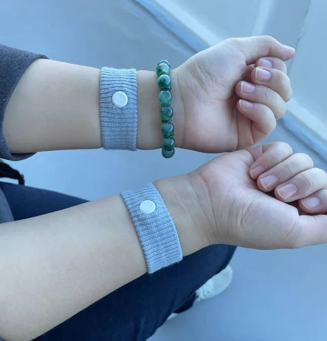 Gray Sea-Band acupressure wristbands worn on both wrists