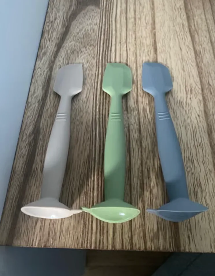 Three soft silicone diaper cream spatulas in grey, white and green side by side