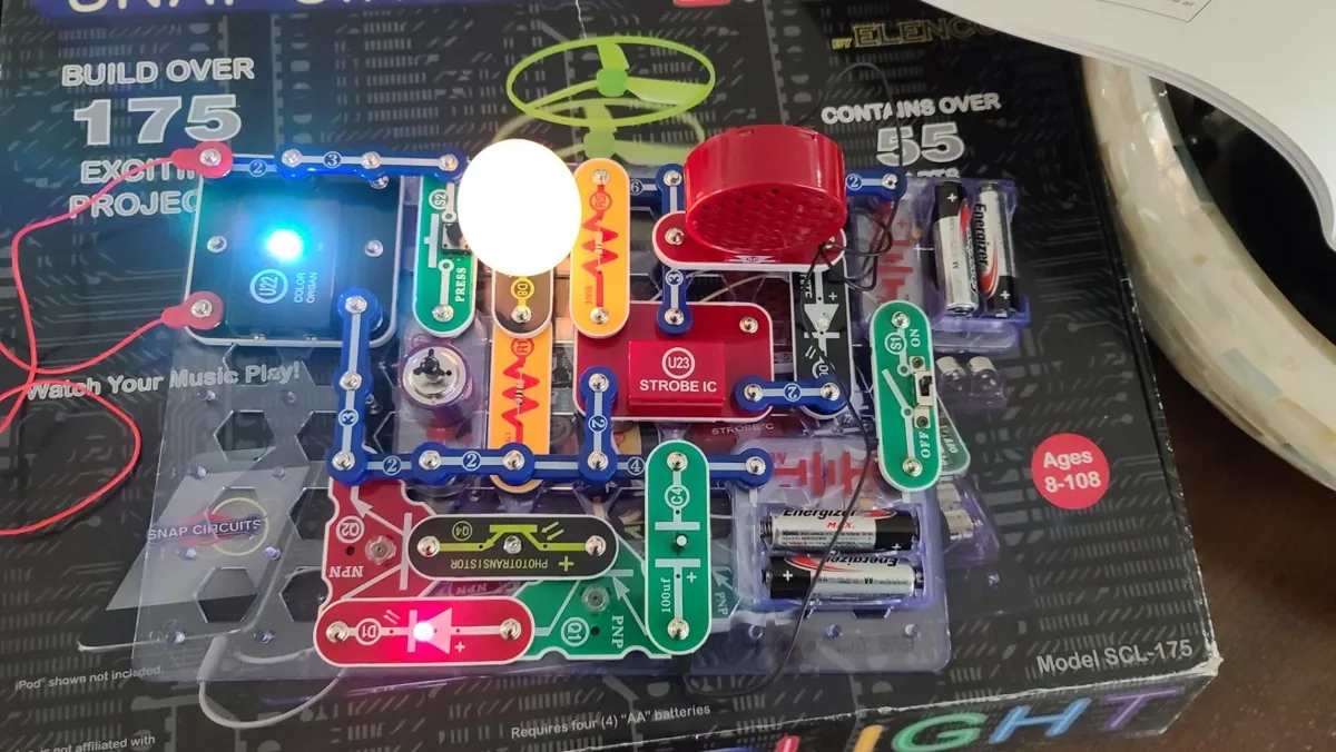Snap Circuits Light board lit up with a finished electronics project