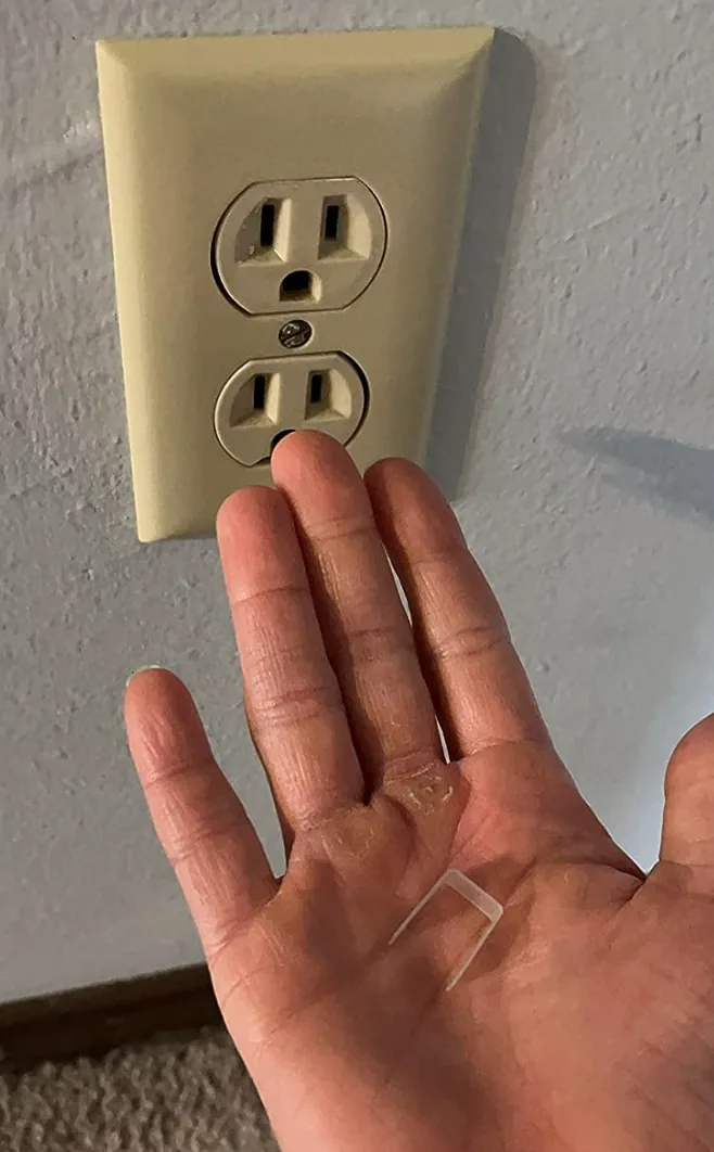 Hand holding a small Snug Plug insert for loose outlets