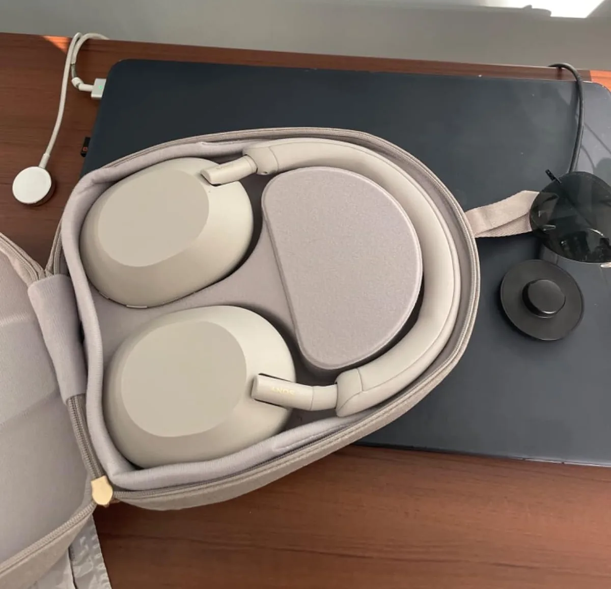 Sony WH-1000XM5 headphones folded in their carrying case on a desk