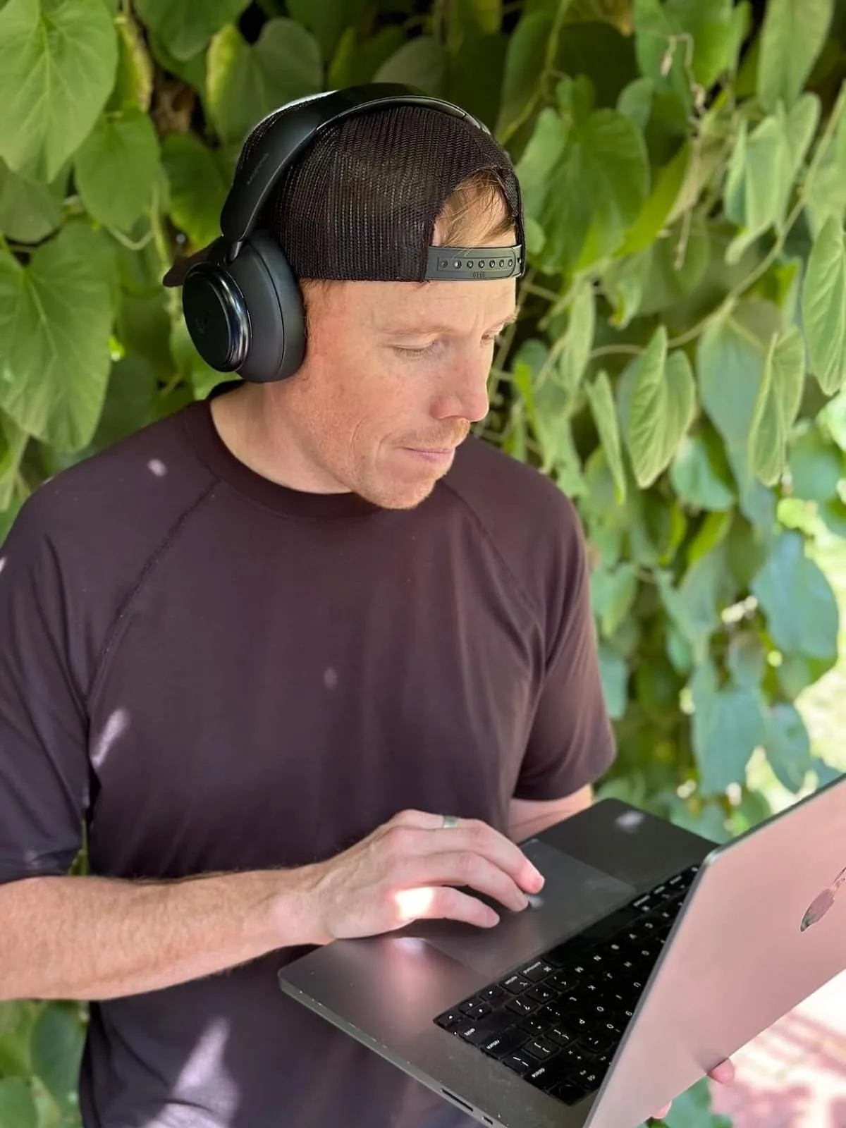 Man wearing Soundcore Space Q45 headphones while typing on a laptop