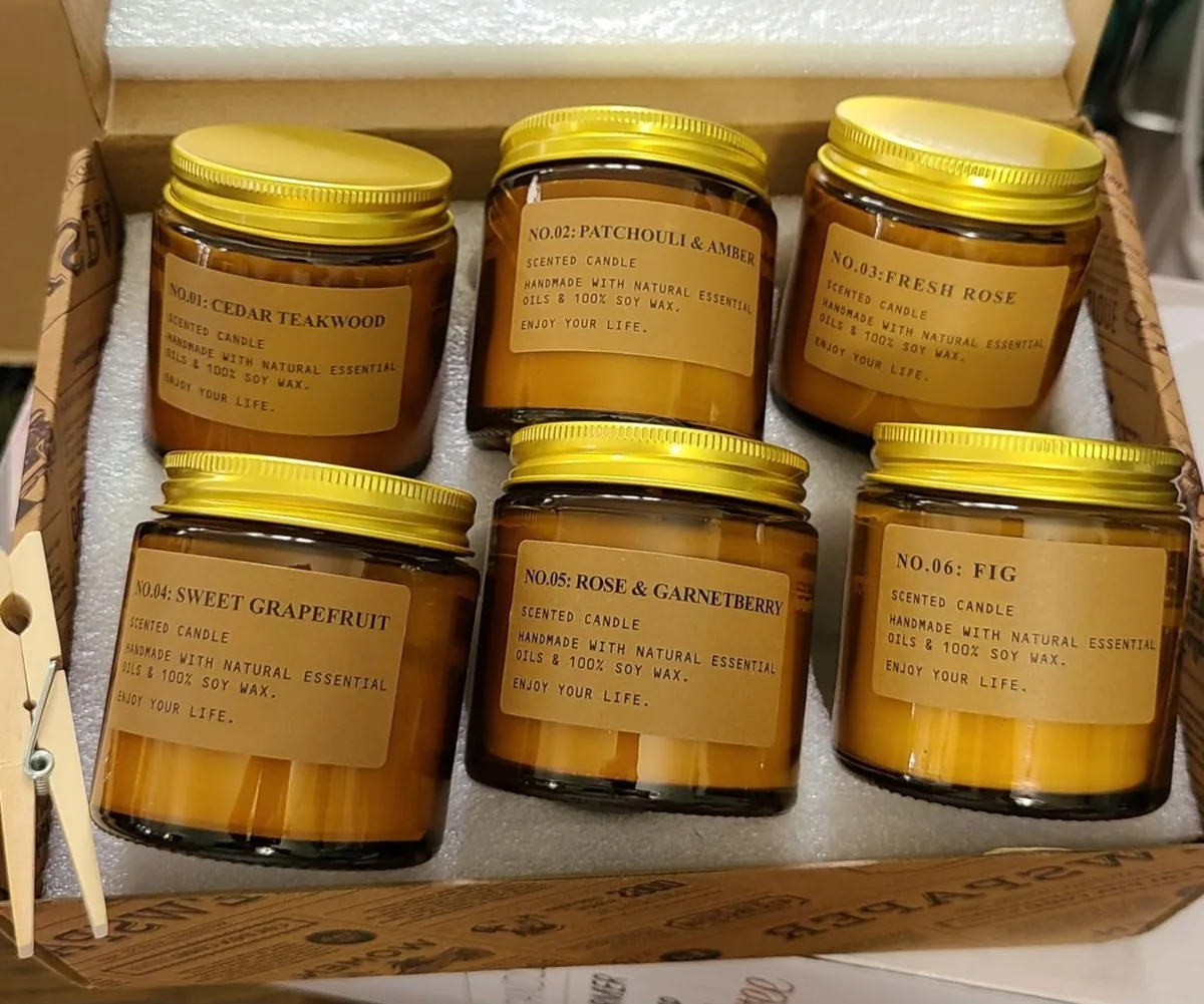 Six amber-jar soy wax candles with gold lids in a gift box