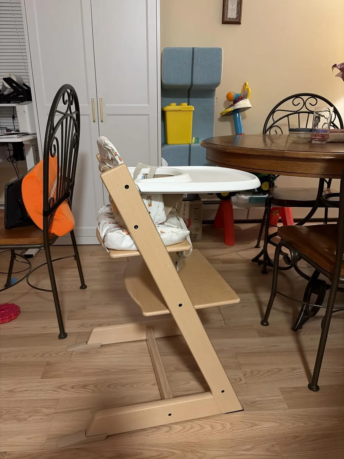 Natural beech Stokke Tripp Trapp chair with baby set and tray beside a dining table