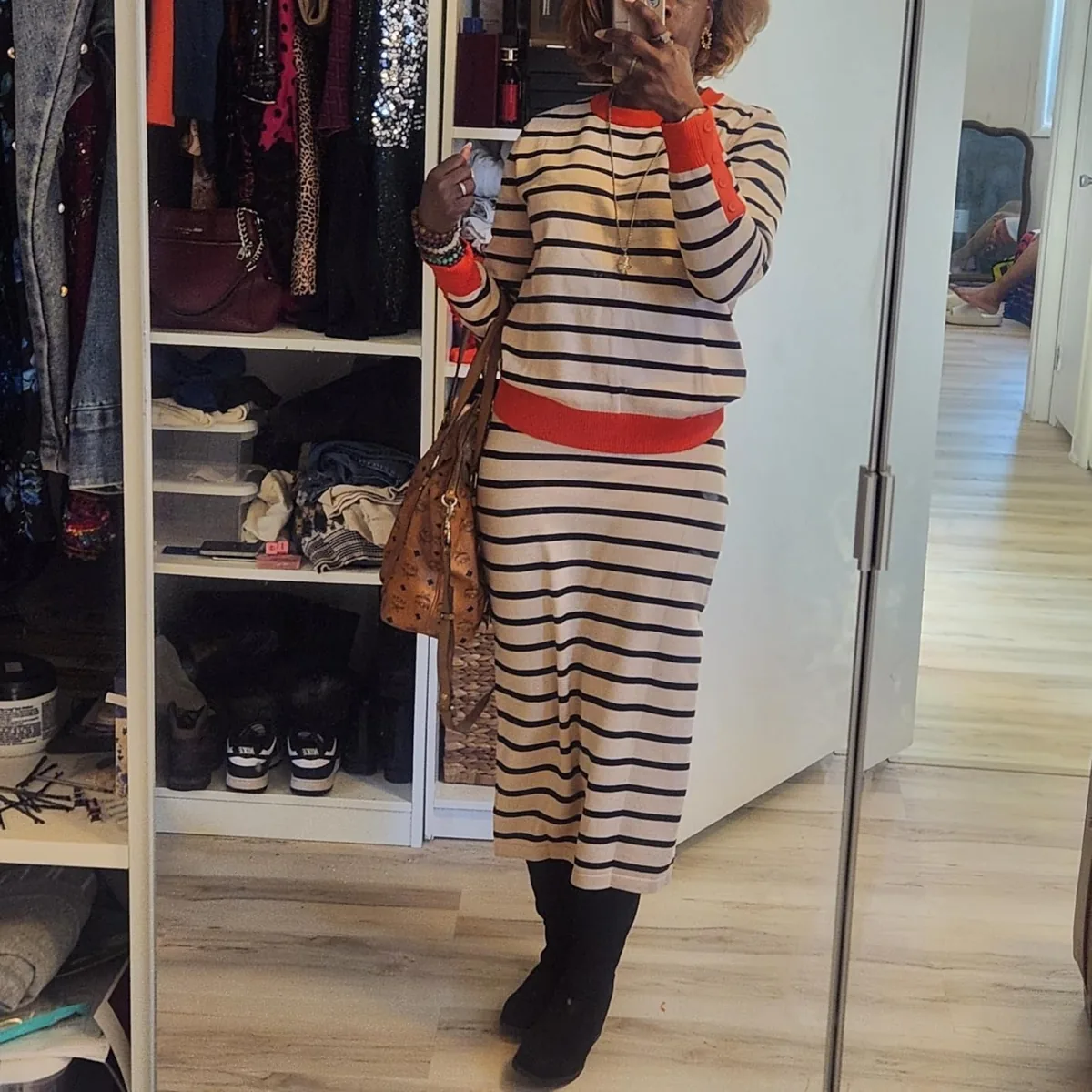 Striped knit sweater and matching midi pencil skirt worn with boots and a tote