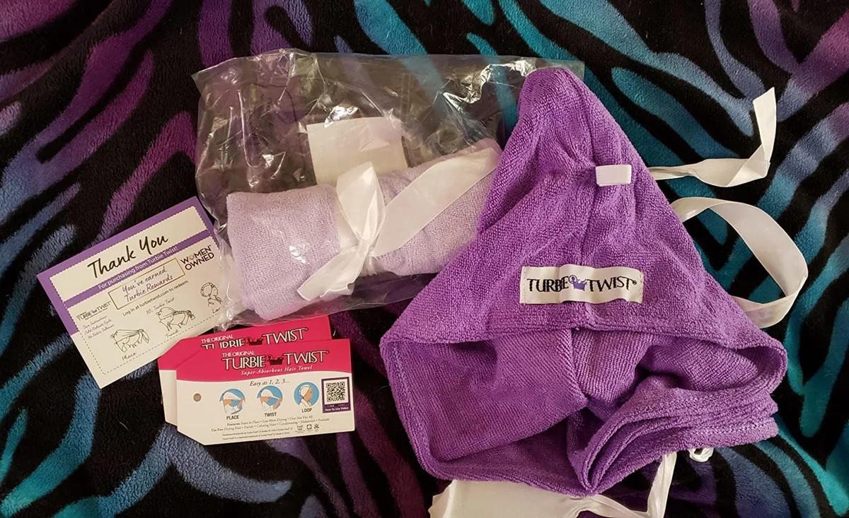 Purple microfiber hair towel wrap laid flat next to its packaging