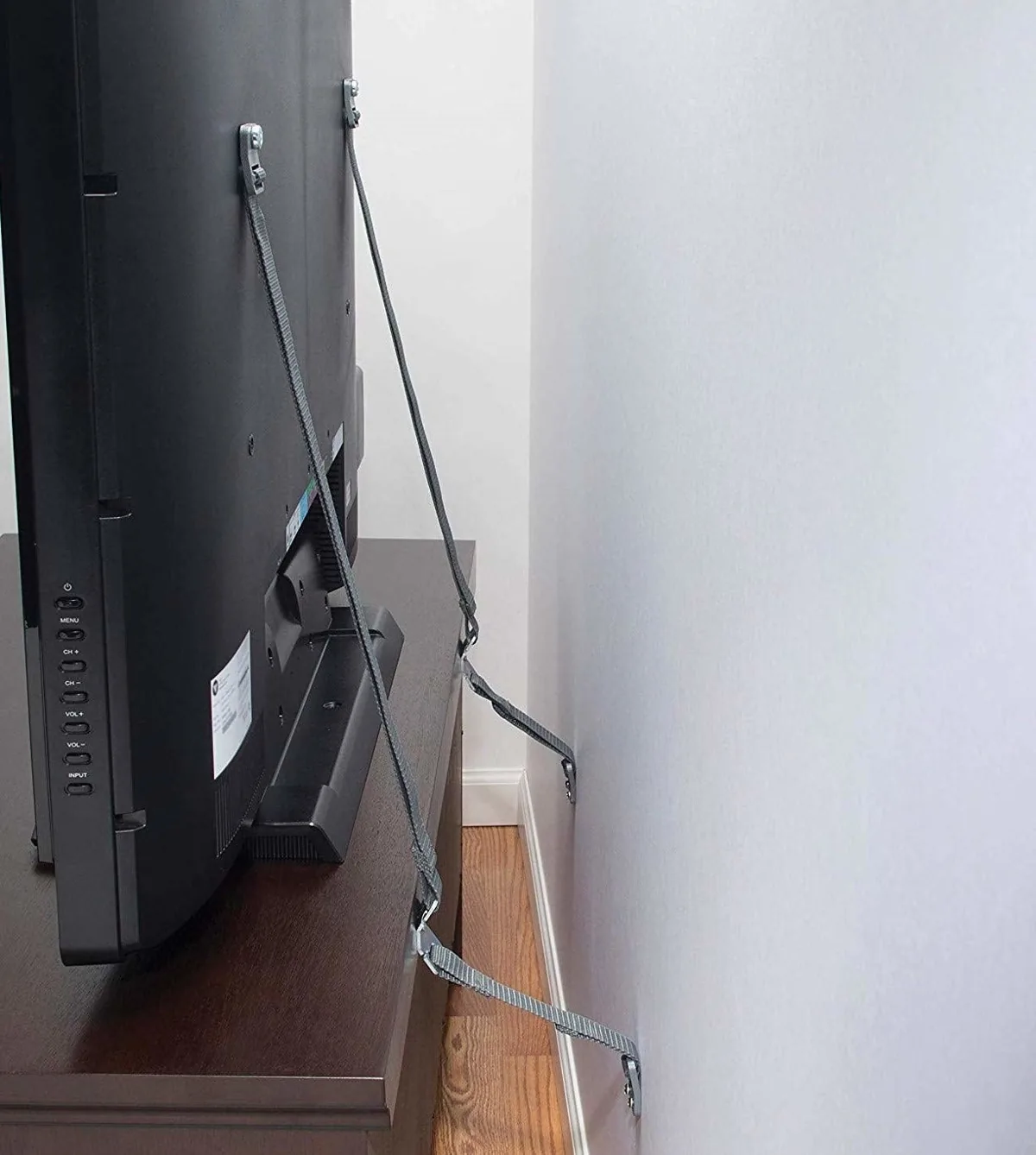 Safety straps anchoring a TV to the wall