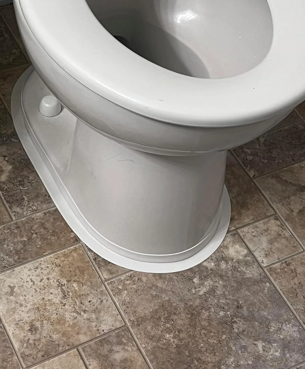 Toilet base sealed with white self-adhesive caulk tape